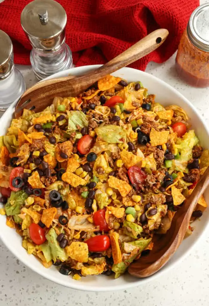 A fun and easy taco salad with seasoned ground beef, black olives, tomatoes, corn, black beans, a healthy helping of cheese, and Doritos Tortilla Chips tossed in a homemade Catalina Salad Dressing.