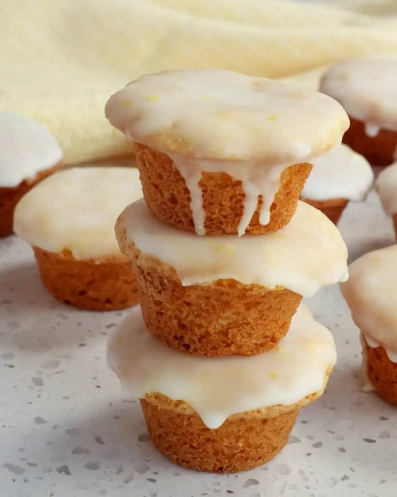 A stack of iced lemon blossoms with a yellow striped kitchen towel in the background.