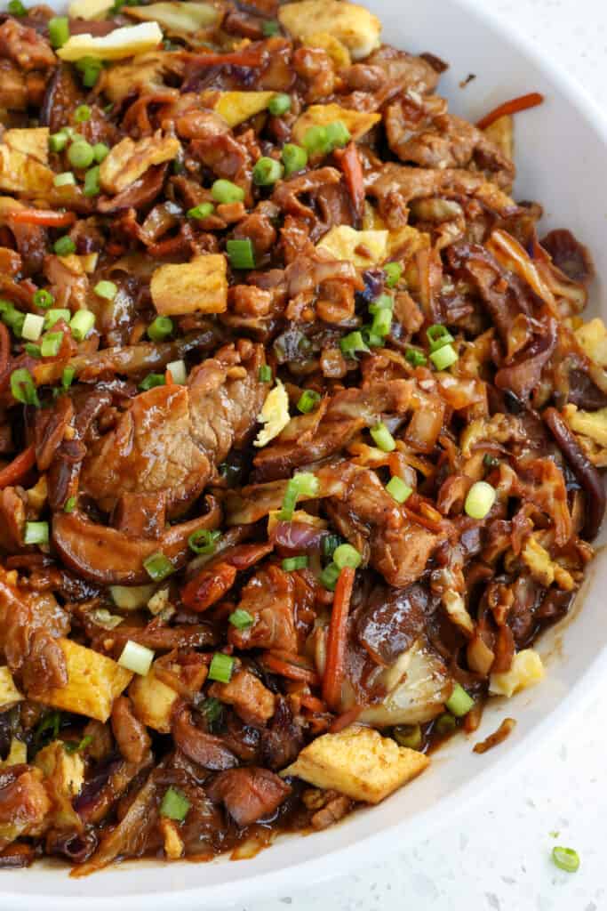 Moo Shu Pork combines thin slices of marinated pork combined with cabbage, carrots, mushrooms, eggs, and green onions in an easy savory sauce made with Hoisin, garlic, ginger, and black pepper. 