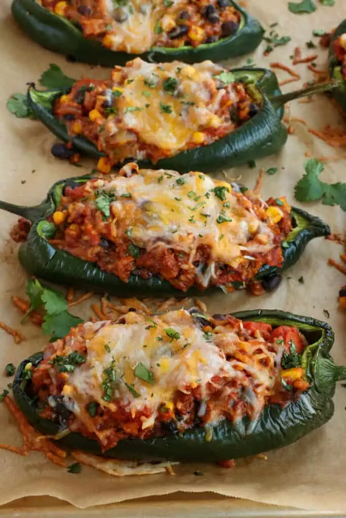 Baked Stuffed Poblano Peppers are loaded with ground beef, onion, garlic, white rice, corn, black beans, fire-roasted tomatoes, and melty Monterey Jack and cheddar cheese.