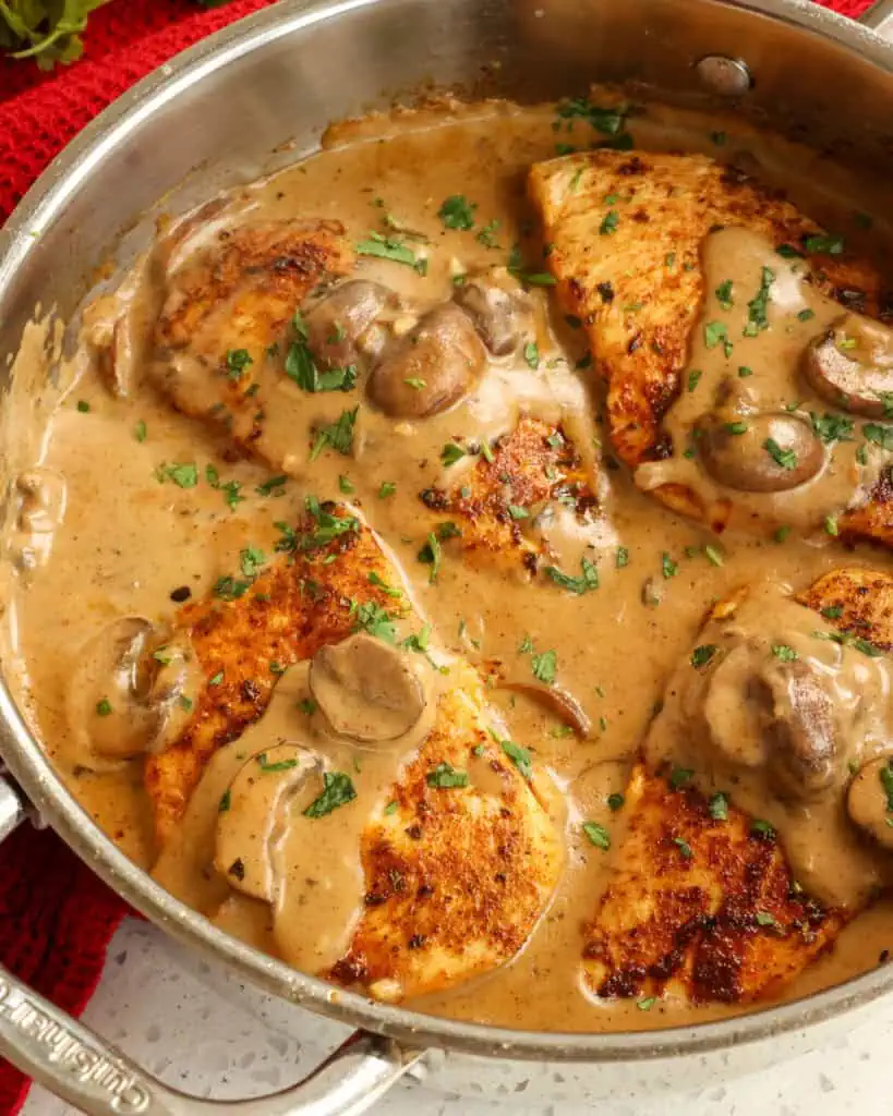 A skillet full of Cajun chicken with a creamy mushroom Cajun sauce. 