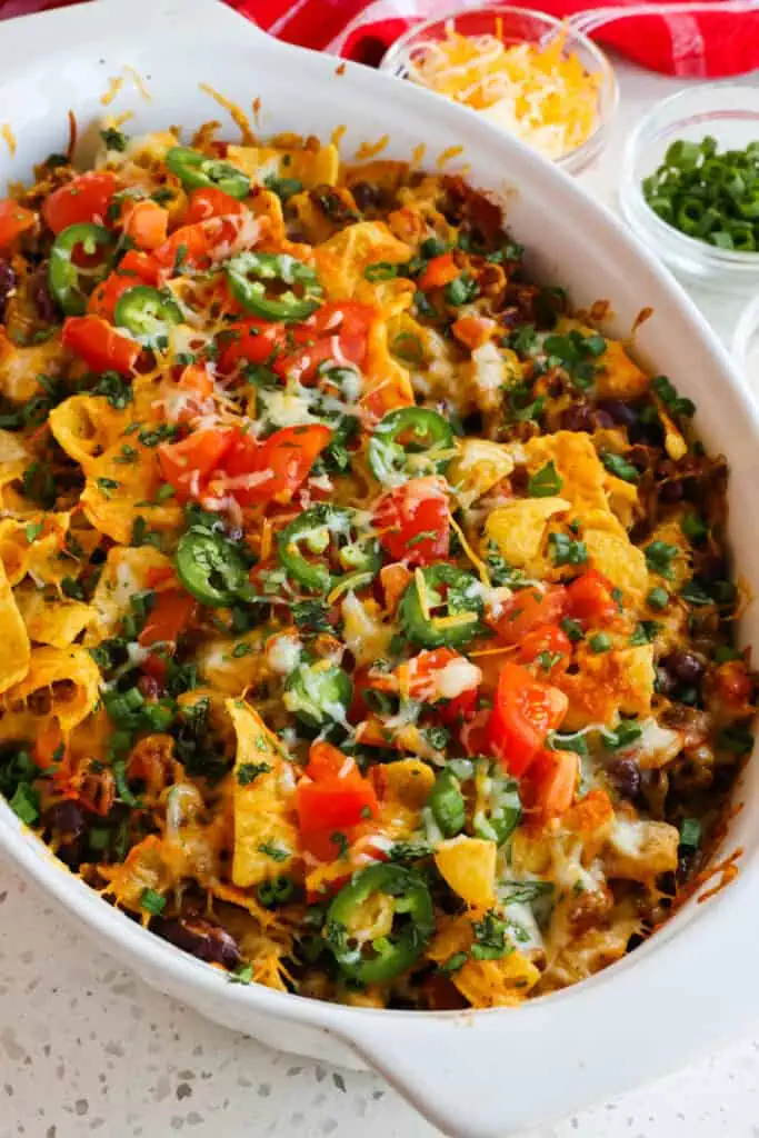This fun and easy Frito Pie combines taco-seasoned ground beef, beans, and tomatoes, all topped with cheddar, Monterey Jack, and crispy, crunchy Fritos.  
