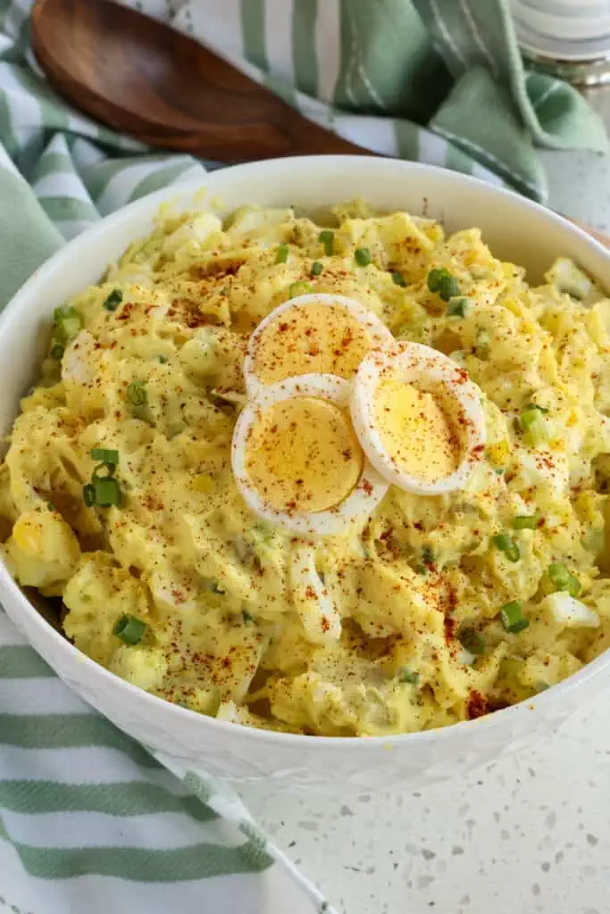 Easy southern potato salad combines potatoes, celery, green onions, pickle relish, and hard-boiled eggs, in a creamy mayonnaise-based dressing with a touch of mustard. 