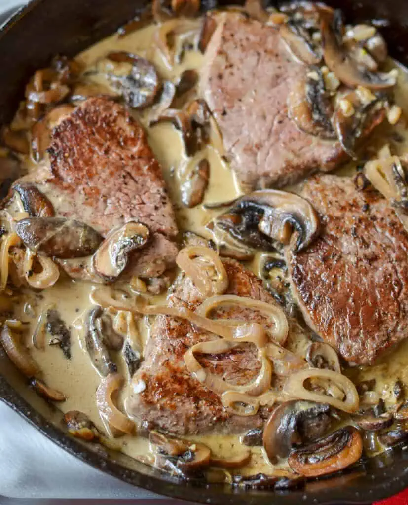 Steak Diane is served with a tasty sauce made from the pan juices, brandy, beef broth, and cream, with browned mushrooms.