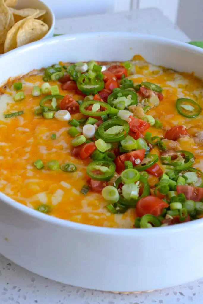This Warm Bean Dip is so easy to fix, and everyone loves it.  I love to top it with sliced jalapenos, green onions, and tomatoes right down the center of the dip.