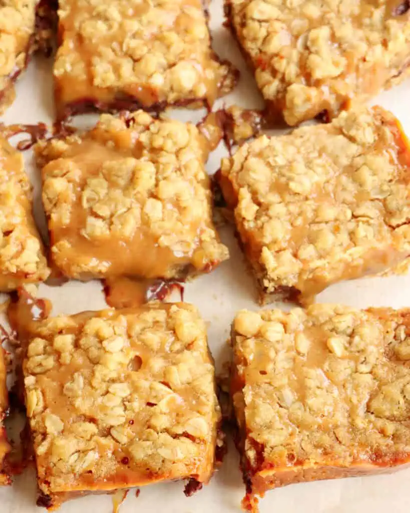 Cut carmelita bars on a parchment paper cutting board. 