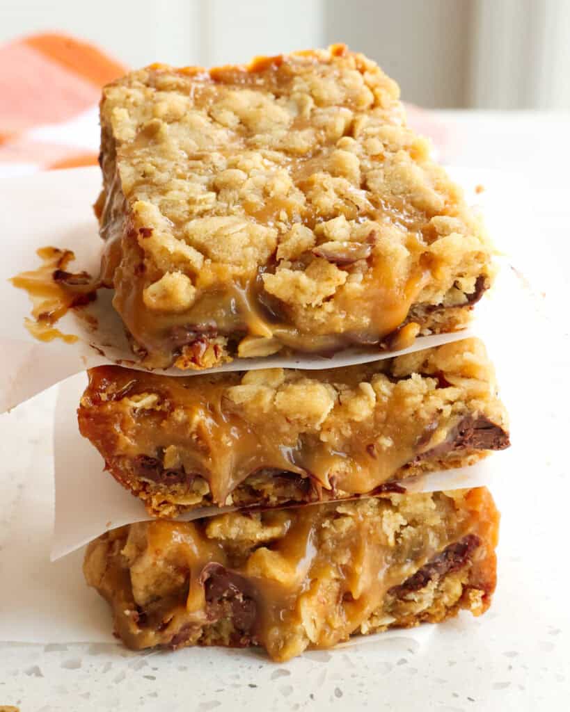 Carmelita bars stacked with parchment paper between them. 