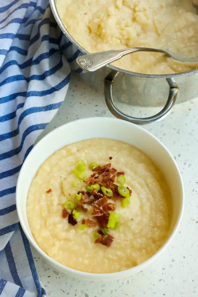 Top the grits with bacon crumbles, sliced green onions, and a little more grated cheese.