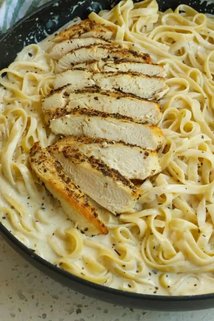 Delicious Chicken Alfredo is the ultimate comfort food dish with tender chicken breasts and fettuccine noodles in a classic Alfredo Sauce made with butter, fresh garlic, heavy whipping cream, Italian seasoning, and freshly grated Parmesan Cheese.  