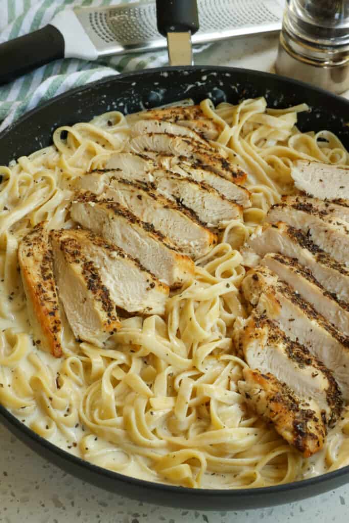 A deliciously easy cream Chicken Alfredo recipe made with golden brown seasoned chicken breast, fettuccini pasta, and a luscious alfredo sauce made with cream and freshly grated Parmesan Cheese. 