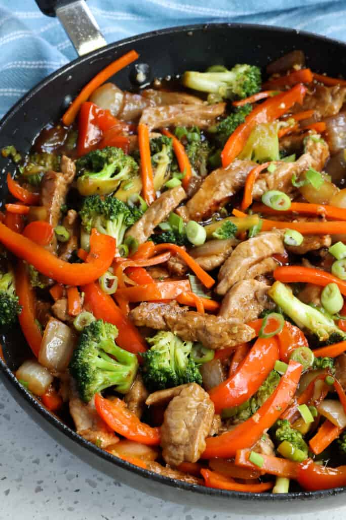 A deliciously easy Pork Stir Fry Recipe with onions, broccoli, red bell peppers, and carrots all in a mouthwatering good garlic ginger sesame sauce.