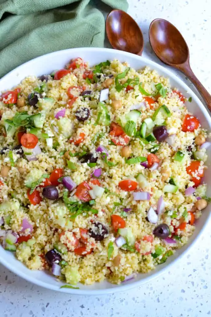 A quick and refreshing Mediterranean Couscous Salad made with instant couscous, English Cucumbers, Kalamata Olives, sun ripened tomatoes, red onion, garbanzo beans, and fresh basil all drizzled with a lemon vinaigrette.