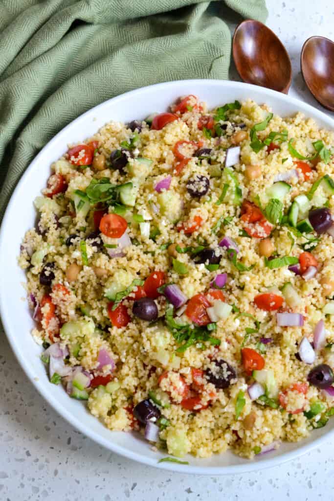 This delicious Mediterranean Couscous Salad combines couscous with cucumber, red onion, tomatoes, garbanzo beans, Kalamata Olives, and feta cheese, all drizzled with an easy three-ingredient lemon vinaigrette. 