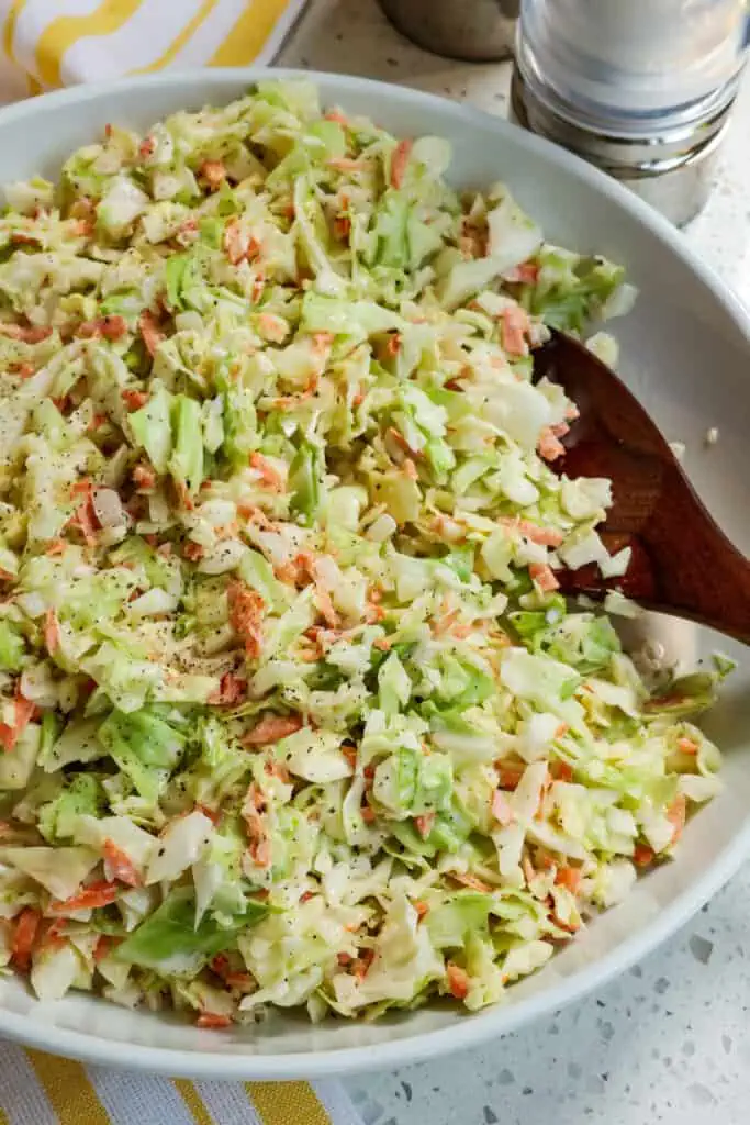 Add the dressing to the shredded cabbage mixture and stir to combine. Season with salt and pepper to taste.