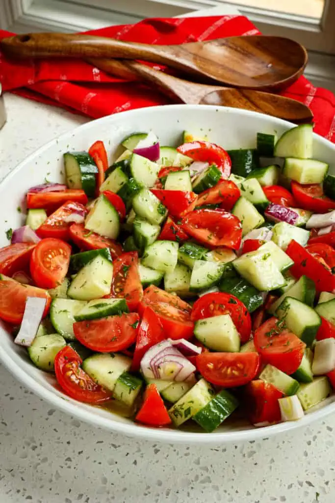 A quick and easy fresh cucumber and tomatoes salad drizzled with a four-ingredient vinaigrette and topped with fresh herbs. 