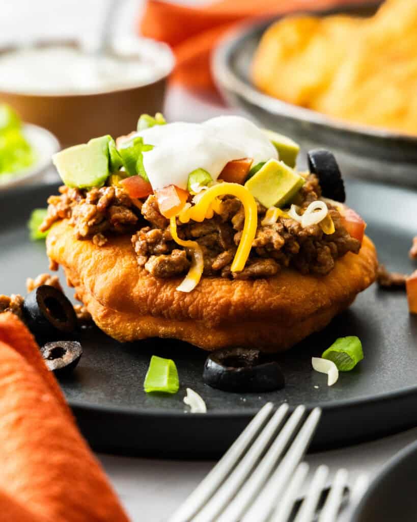 Indian Fry Bread A close up view of Navajo Tacos with fry bread and sour cream in the background.
