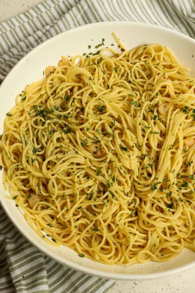 This quick and easy Garlic Pasta combines pan-roasted garlic, olive oil, and Parmesan cheese tossed with spaghetti and seasoned with fresh herbs like parsley and thyme.