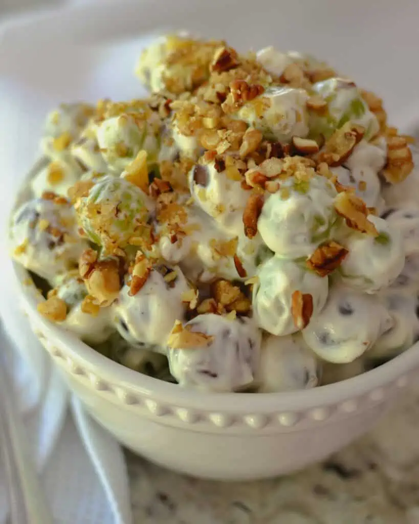 This creamy grape salad is a unique family and friend favorite recipe. It is a delectable combination of both red seedless grapes and green seedless grapes, cream cheese, and sour cream, with pecans, walnuts, and brown sugar for a little sweet crunch.