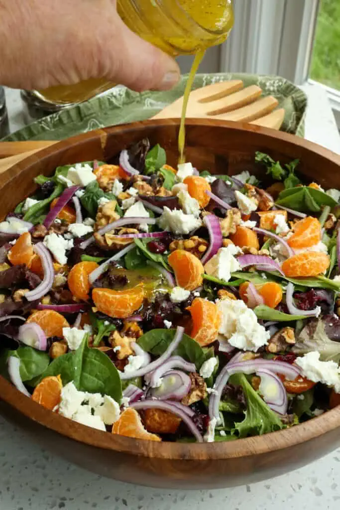 A light and refreshing Mandarin Orange Salad made with mixed greens, toasted walnuts, dried cranberries, and crumbled feta cheese, all drizzled with a six-ingredient orange vinaigrette. 