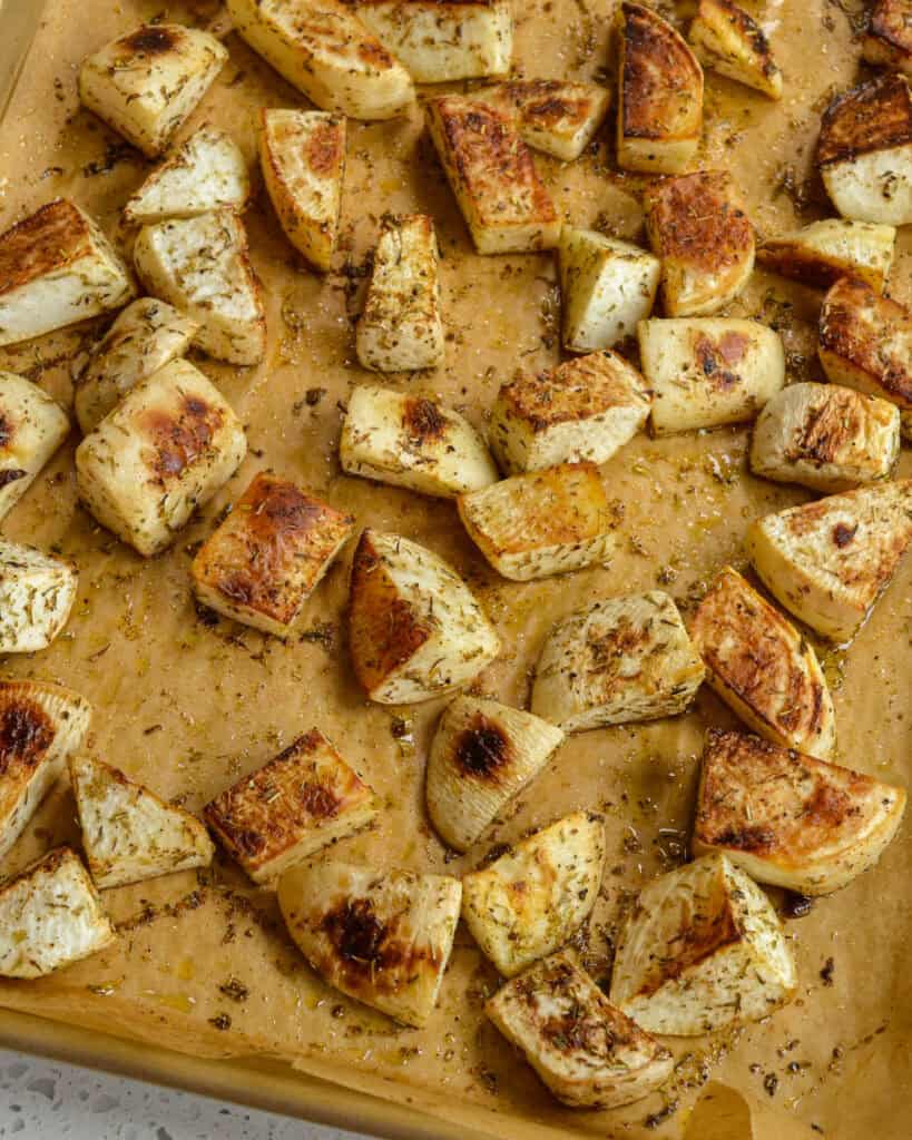 Roasted Turnips on parchment on a baking sheet.