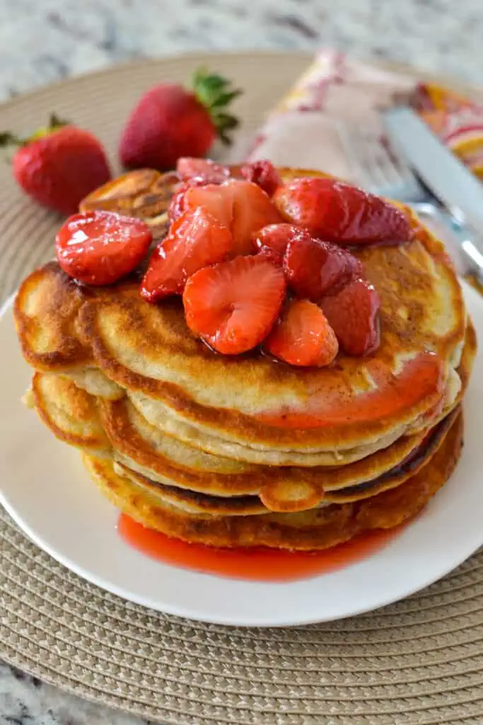 Perfectly light and crispy strawberry pancakes are topped with sweet fresh strawberries for the perfect weekend brunch