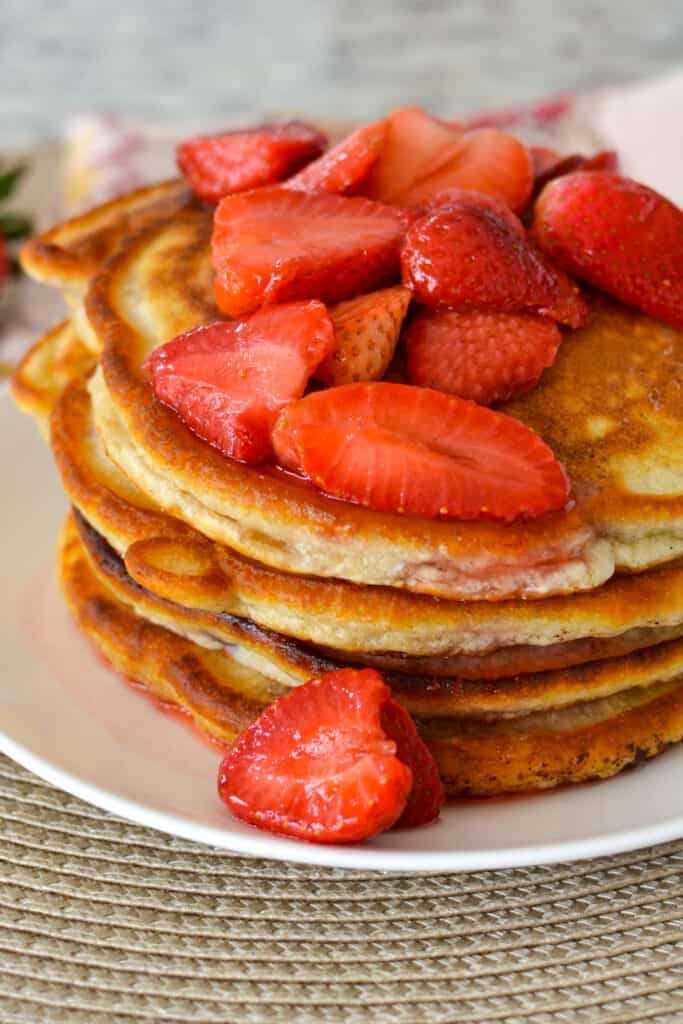 These light and fluffy strawberry pancakes are topped with fresh strawberries coated in a light and sweet sauce.