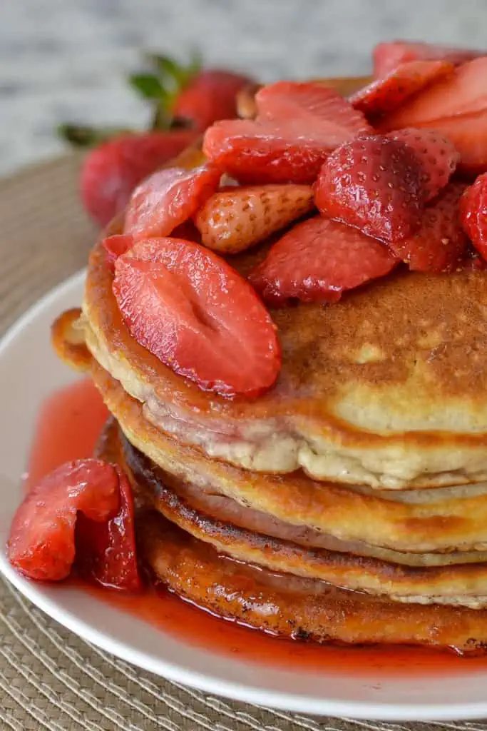 These made-from-scratch strawberry pancakes are perfectly light, fluffy, and crispy around the edges. Topped with fresh strawberries and a lightly sweet strawberry sauce, these homemade pancakes are a perfect weekend brunch recipe.