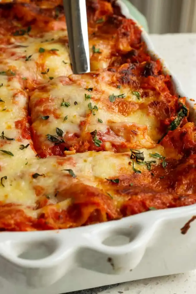 Let the lasagna rest and cool for about 15-20 minutes before slicing.  This helps the layers stay intact when slicing and removing it from the pan. 