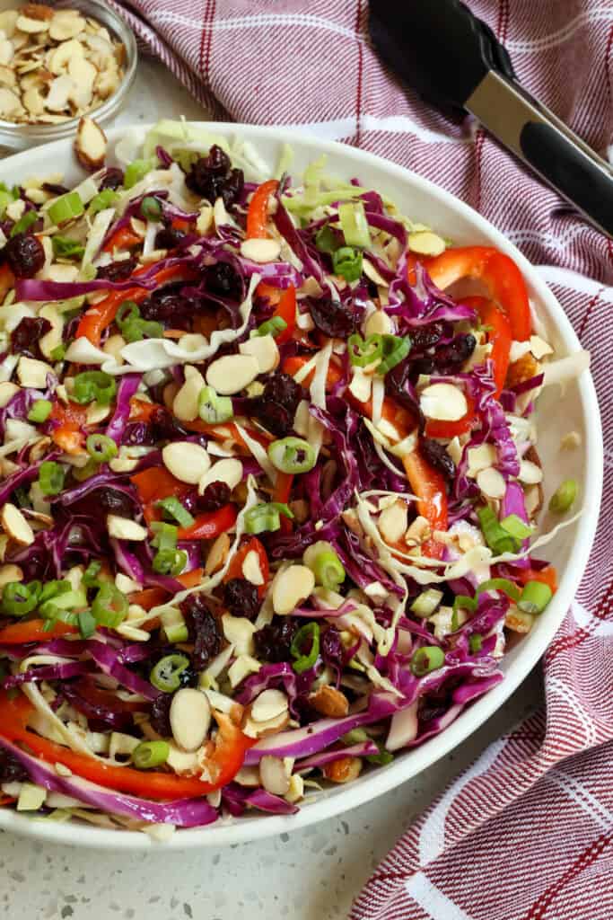 This tasty Cabbage Salad combines green cabbage, red cabbage, red bell pepper, red onions, almonds, and dried cranberries, all drizzled with a sweet and tangy honey mustard ginger vinaigrette. 