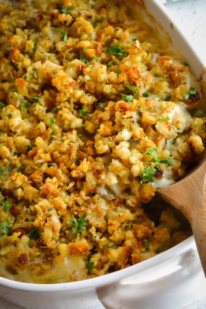 A tasty Chicken Stuffing Casserole plump full of onions, celery, carrots, potatoes, and rotisserie chicken in a creamy gravy, all topped with a layer of herb stuffing and baked to golden perfection. 