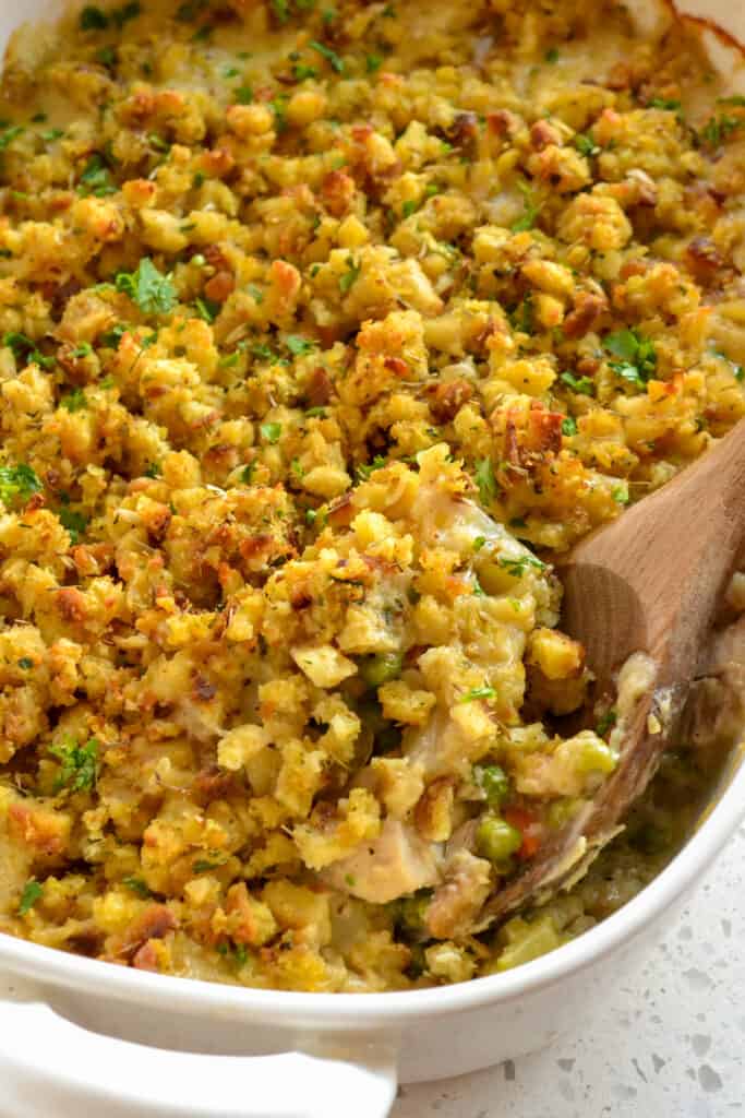 A scrumptious made-from-scratch chicken stuffing casserole with onions, carrots, celery, and potatoes in a homemade sauce, all topped with stuffing and baked to perfection.