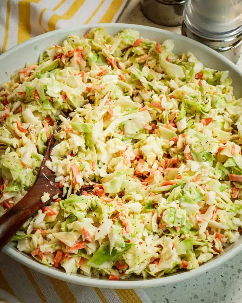 Creamy Coleslaw up close with a wooden in the white bowl.