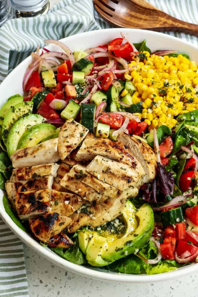 This Grilled Chicken Salad is bursting with flavor from corn, avocados, tomatoes, cucumbers, bell pepper, and red onion, and all drizzled with a sweet and tangy honey mustard vinaigrette. 