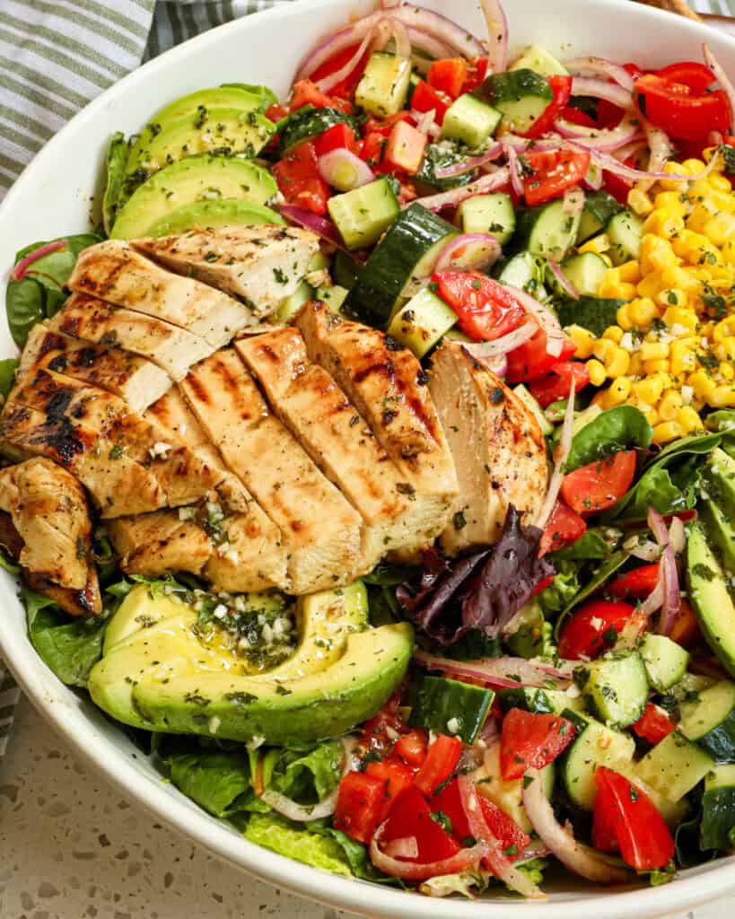 This Grilled Chicken Salad is bursting with flavor from corn, avocados, tomatoes, cucumbers, bell pepper, and red onion, and all drizzled with a sweet and tangy honey mustard vinaigret