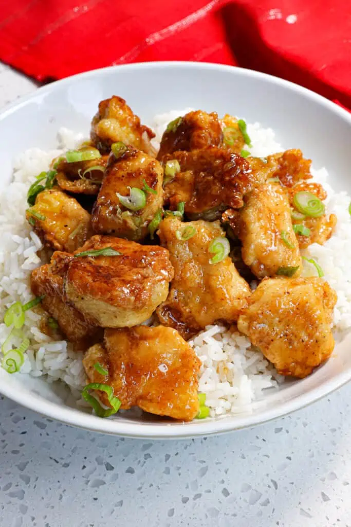 This quick and easy mouthwatering good Honey Garlic Chicken combines crispy Asian-style fried chicken pieces and green onions tossed in a quick and easy honey garlic sauce.
