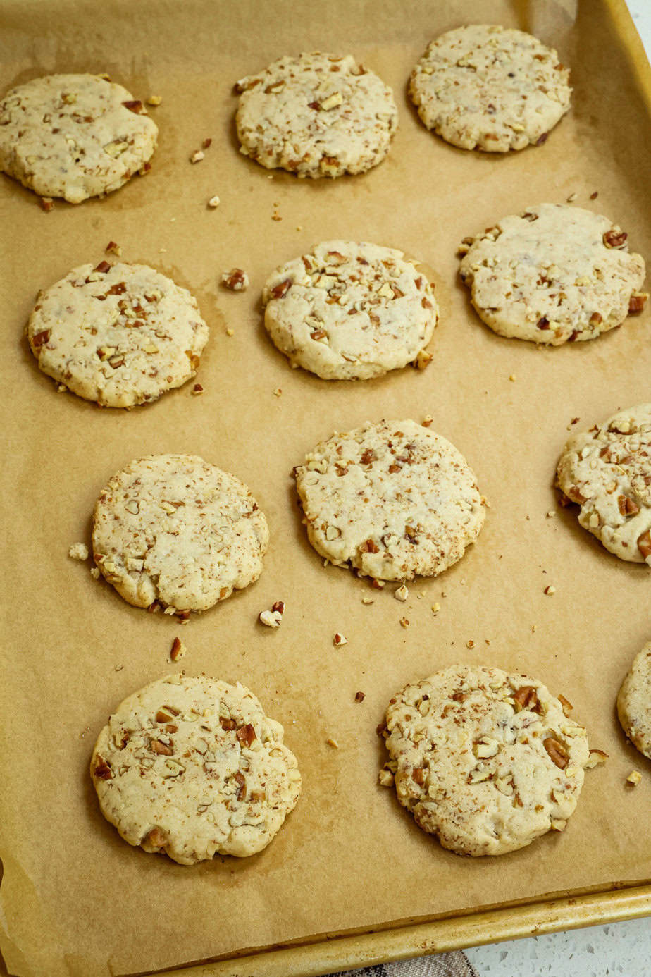 Baked pecan sandeis on a baking sheet with parchment paper. 