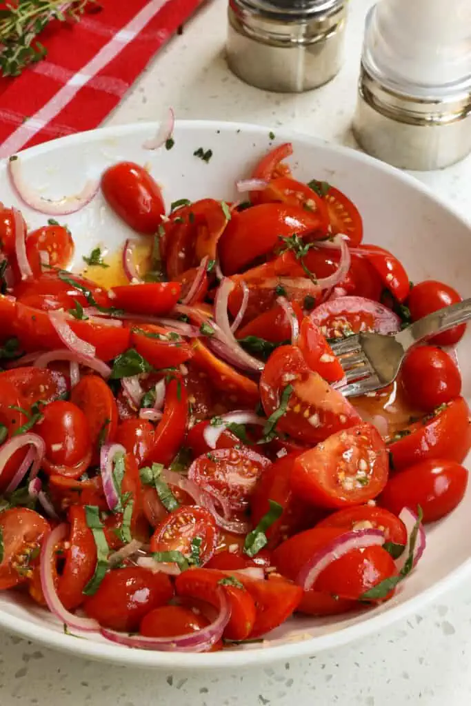 A delicious Tomato Salad in an easy vinaigrette made with simple ingredients that bring out the best that tomato season has to offer.
