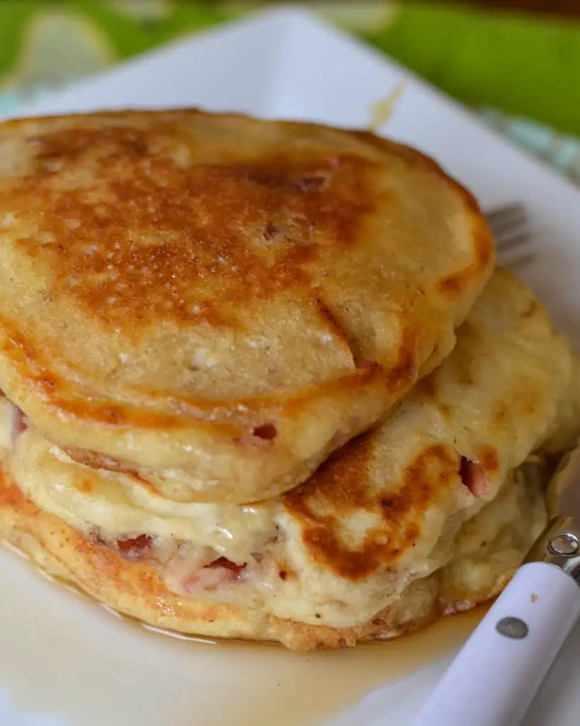 Buttermilk Bacon Pancakes are light fluffy pancakes with crisp edges and bits of hearty smoked bacon in every bite topped with a cherry whiskey maple syrup.