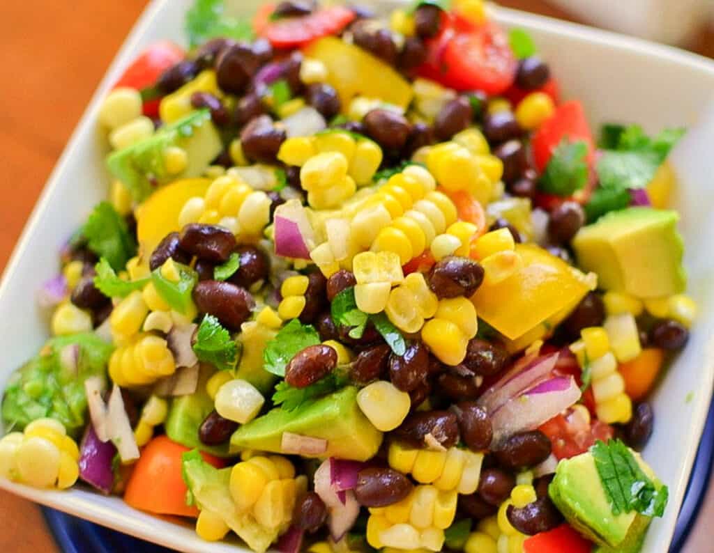 Black bean and corn salad with tomatoes and avocadoes in a bowl. 