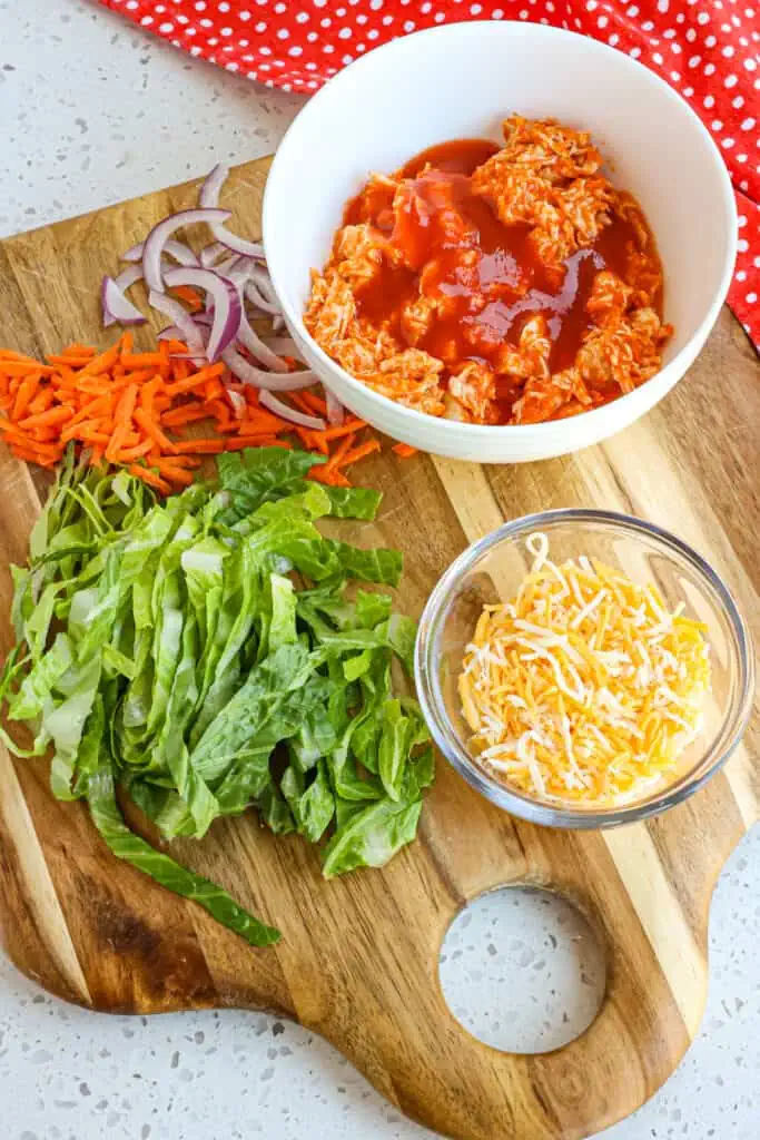  They are made with buffalo sauce, ready-cooked rotisserie chicken breasts, shredded romaine lettuce, thin slices of red onion, shredded carrots, and shredded cheddar and Monterey Jack Cheese, all drizzled with your favorite bottled ranch or bleu cheese dressing. 