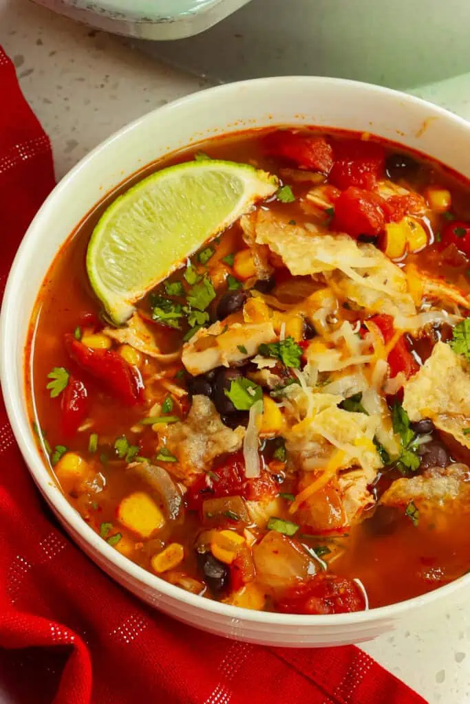 This delectable quick and easy Chicken Taco Soup is bursting with flavors from tender chicken corn, black beans, fire-roasted tomatoes, and green chiles.