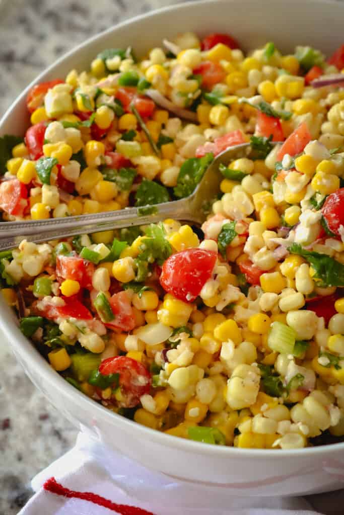 This delectable no mayo corn salad brings it all together with fresh corn, sweet red bell peppers, sun-ripened tomatoes, cilantro, minced jalapeno, chopped scallions, and feta cheese, all in a lightly sweetened lime vinaigrette.  