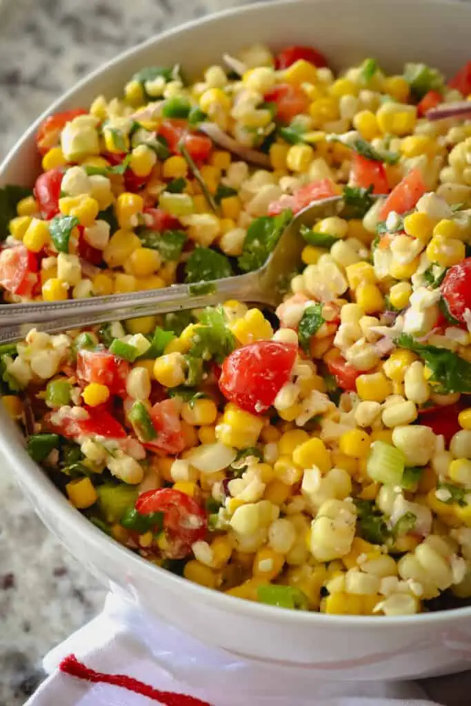 This delectable no mayo corn salad brings it all together with fresh corn, sweet red bell peppers, sun-ripened tomatoes, cilantro, minced jalapeno, chopped scallions, and feta cheese, all in a lightly sweetened lime vinaigrette.  