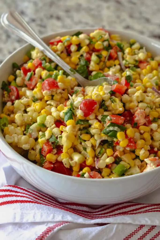 This delectable corn salad brings it all together with fresh corn, sweet red bell peppers, sun-ripened tomatoes, cilantro, minced jalapeno, chopped scallions, and feta cheese, all in a lightly sweetened lime vinaigrette.