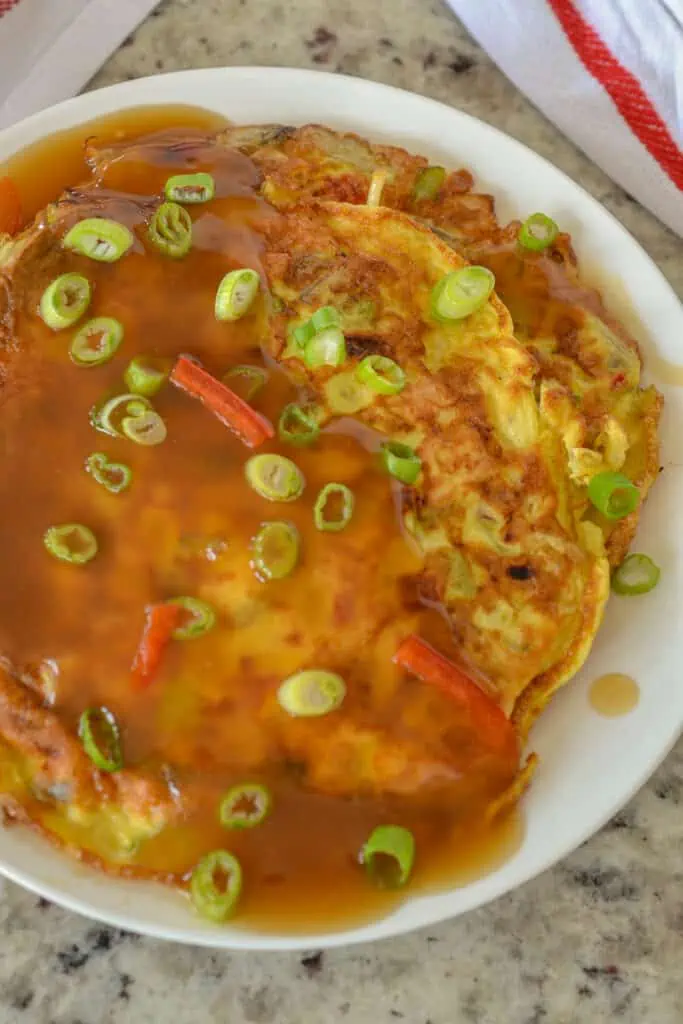 This delectable Egg Foo Young, also known as Egg Foo Yung, is a Chinese-style Omelet filled with red peppers, celery, mushrooms, onions, bean sprouts, scallions, salt, white pepper, and chicken, all smothered in a scrumptious, slightly salty-sweet, tangy gravy. 