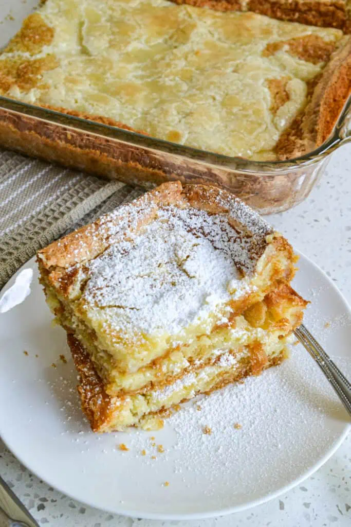 This family friendly Gooey Butter Cake has seven ingredients and takes less than 10 minutes to get in the oven.  It is so popular at potlucks and family reunions that is usually the first dessert gone.  Bake one up for your family today and let them be the judge.