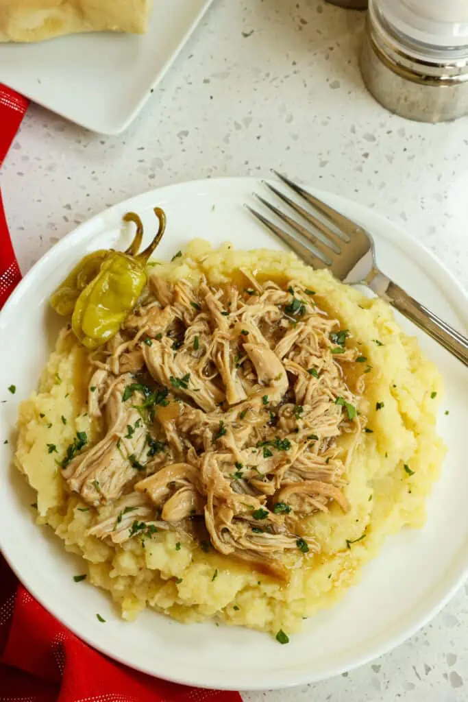 Mississippi Chicken cooks up tender and flavorful in a crock pot with ranch seasoning, dried au jus gravy mix, and pepperoncini peppers.