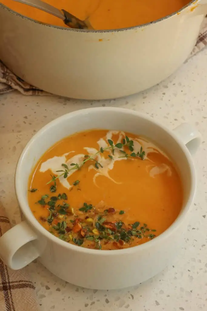 This creamy Sweet Potato Soup is a family favorite seasoned perfectly with garlic, ginger, cumin, and smoked paprika and topped with toasted coconut flakes, chopped pistachios, and fresh thyme.