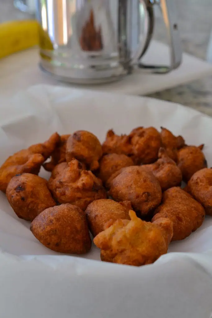 A simple and quick recipe for delectable fried fritters filled with fresh bananas and cinnamon with a pinch of cloves and allspice. Serve these perfectly fried fritters dusted with powdered sugar alongside warmed maple sugar.
