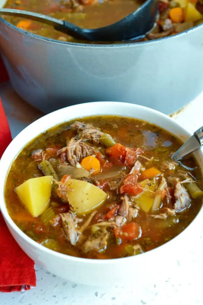 A slow-simmered Vegetable Beef Soup with tender chunks of beef and wholesome fresh vegetables like carrots, potatoes, tomatoes, and green beans.